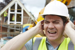 construction worker holding ears with agonizing look